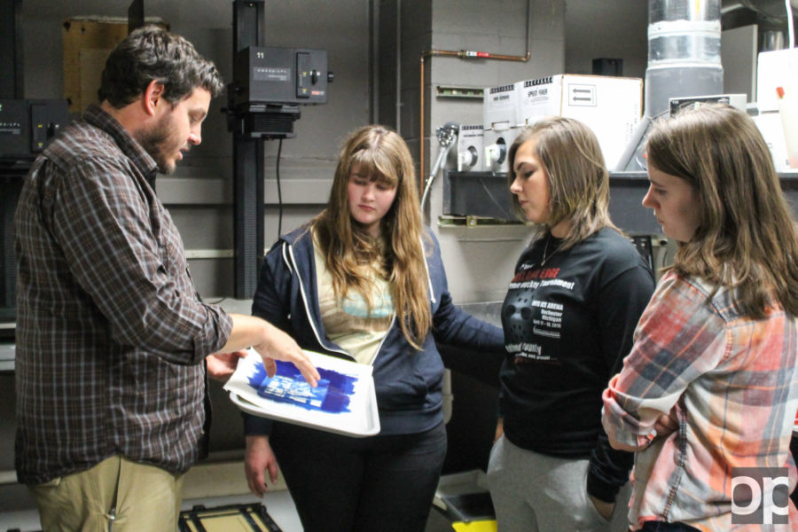 Professor David Lambert help his students with their cyanotype prints in the redesigned dark room on Nov. 11.