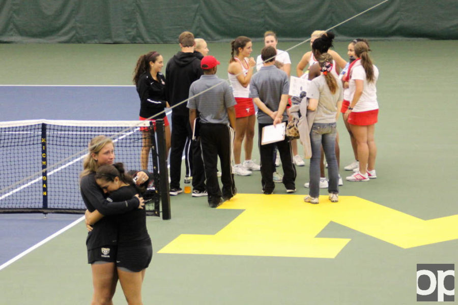 Golden Grizzlies Karine Celis and Maxime Colen embrace in front of a victorious Youngstown State team. Oakland lost 4-1.