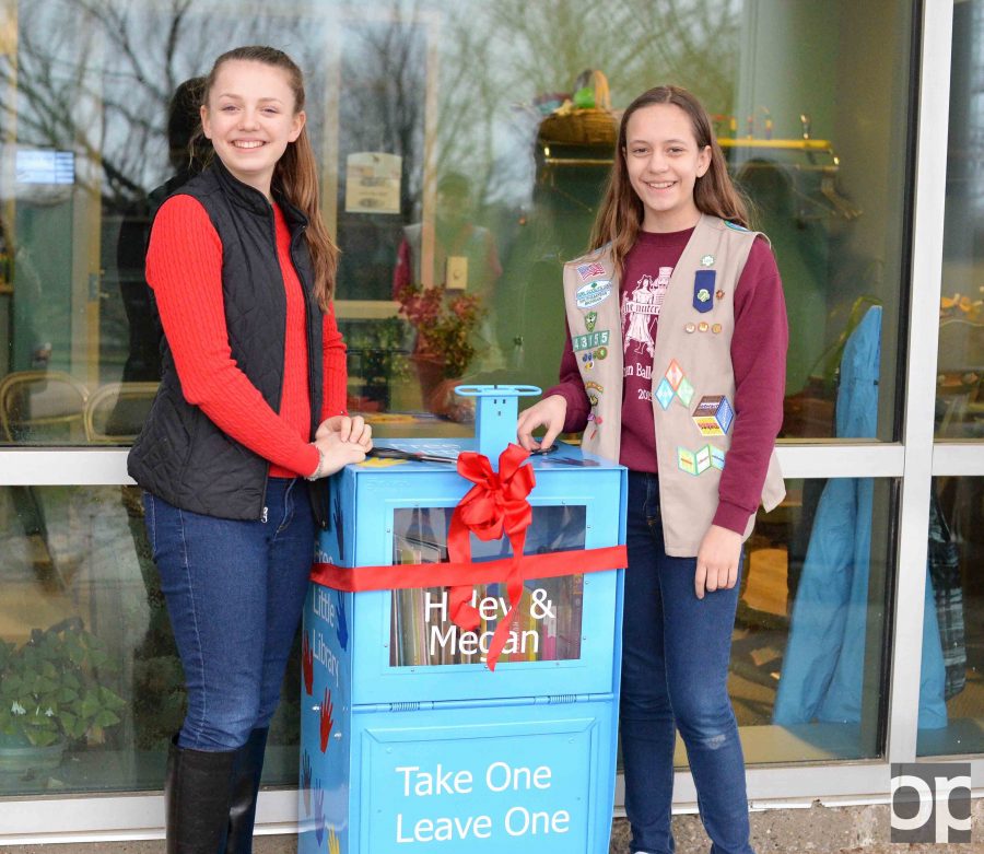 Megan MacKenzie (left) and Haley Evans (right) host a ribbon cutting ceremony for their "Free Little Library" outside the Lowry Early Education Center on Thursday, March 30. 