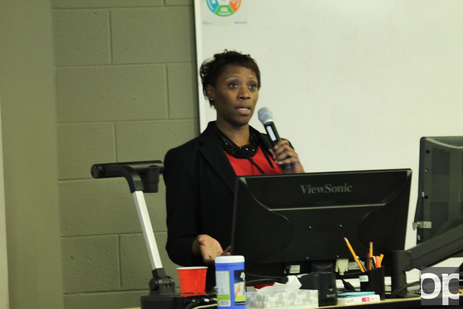 Speaker Michelle George delivers a presentation about HIV/AIDS and how many people are affected by it.