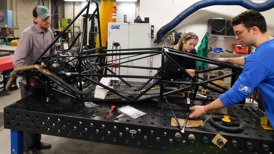 From left: Gavin McPherson, Bella Lane and Adam Delbeke work on the GRX9. Control arms have been added to the sides and the engine has exhaust pipes.