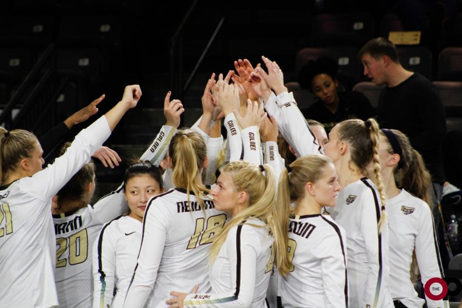 The volleyball team in a huddle during a timeout.