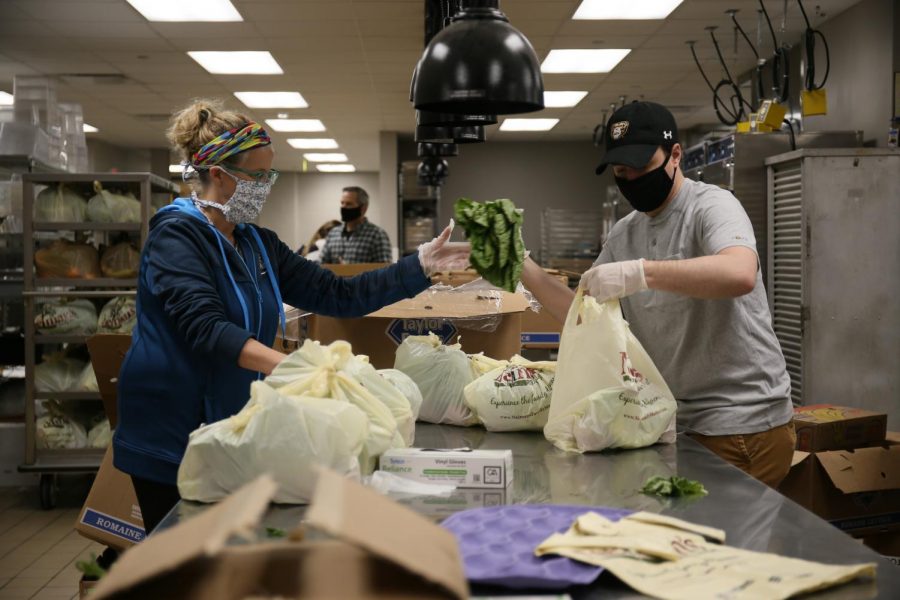 Two volunteers handle produce in the Oakland Center.