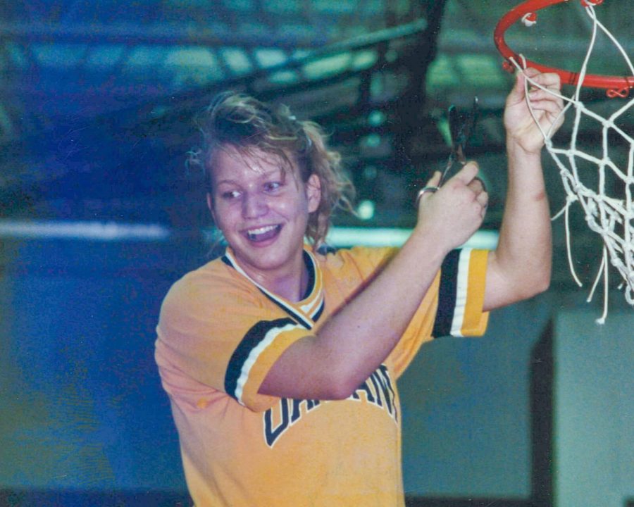 Treys mom, Nicole Leigh, cutting down the net as a Golden Grizzlies basketball player.
