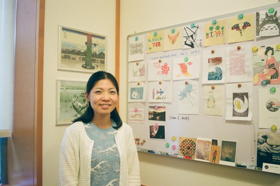 Nozomi Naoi stands next to some of her art collection.