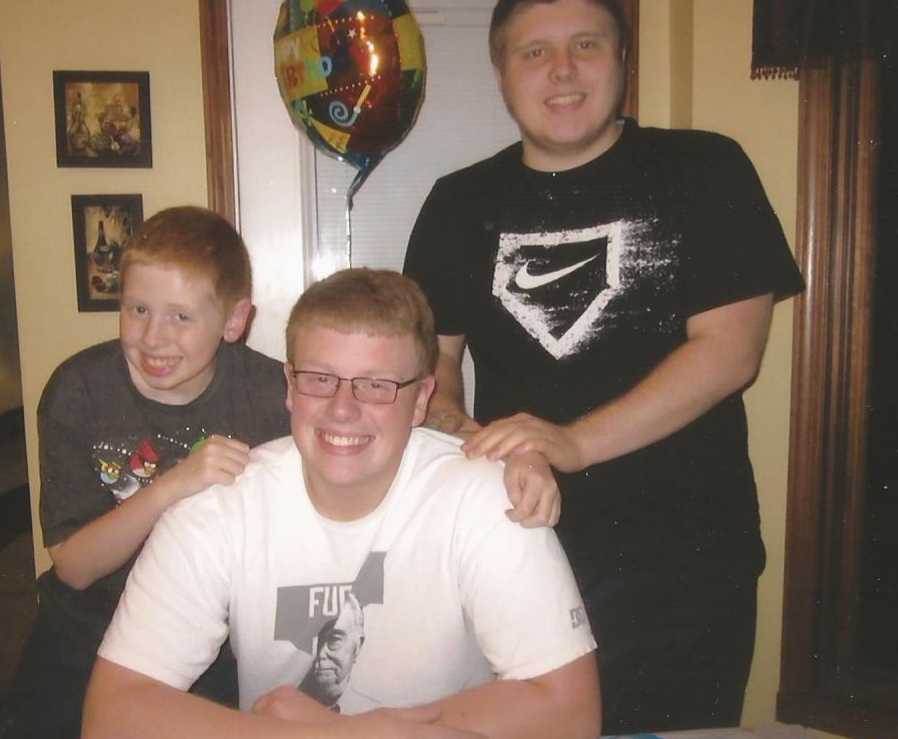 At his childhood home in Capac, MI, Jeff Thomas takes a break from his birthday celebration to pose with his two younger brothers.
