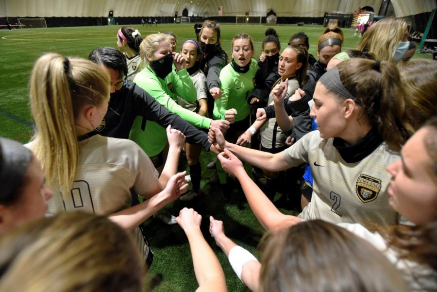 The Oakland womens soccer team in a huddle. 