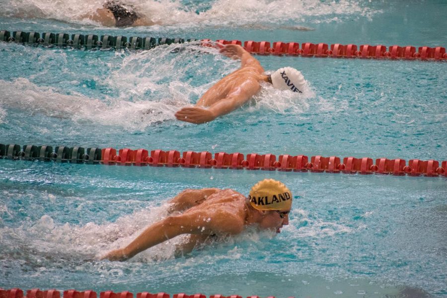 An Oakland swimmer and a Xavier swimmer race up and down the pool during their match on Oct. 23.