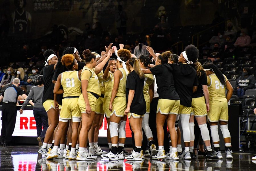 The womens basketball team in a huddle against IU