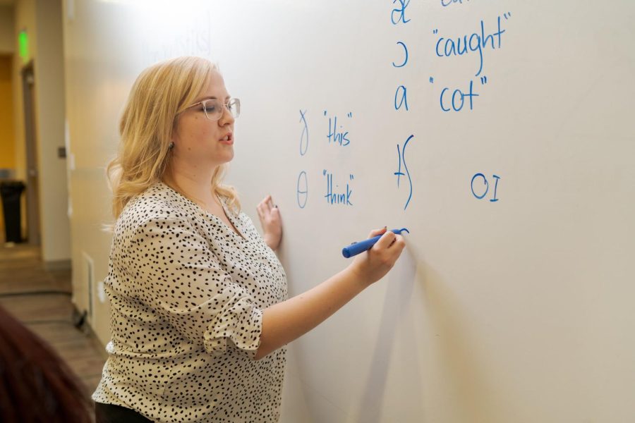 Kerry Macintosh, class of 2021, writes symbols of the International Phonetic Alphabet at the board. The Linguistics Department at OU is now offering a minor in speech language pathology. 