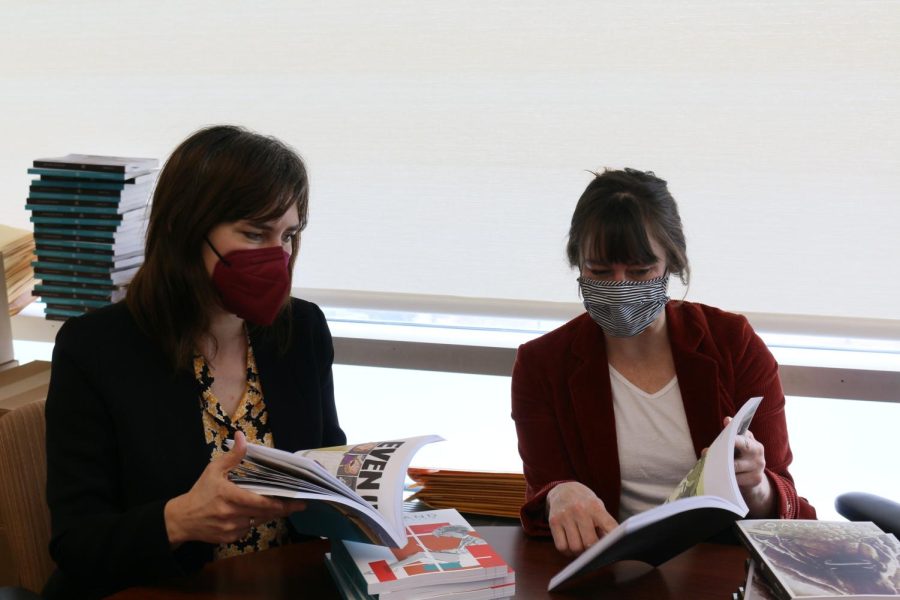 Professor Susan McCarty (left) and Professor Alison Powell (right) admiring some of the art in recent volumes of The Oakland Arts Review.